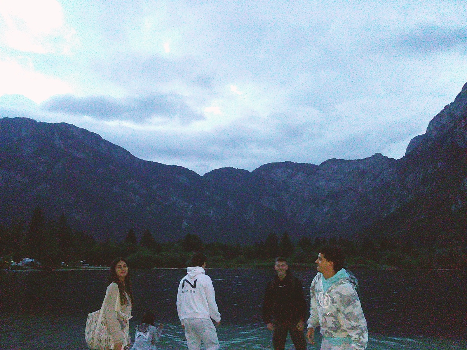 Amigos com roupa Navigo junto a um lago ao anoitecer